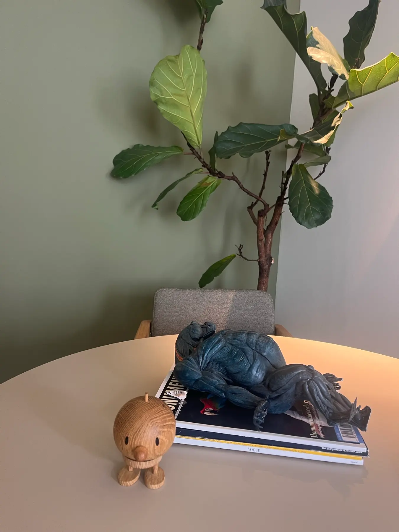 Tafel met tijdschriften en een houten figuurtje